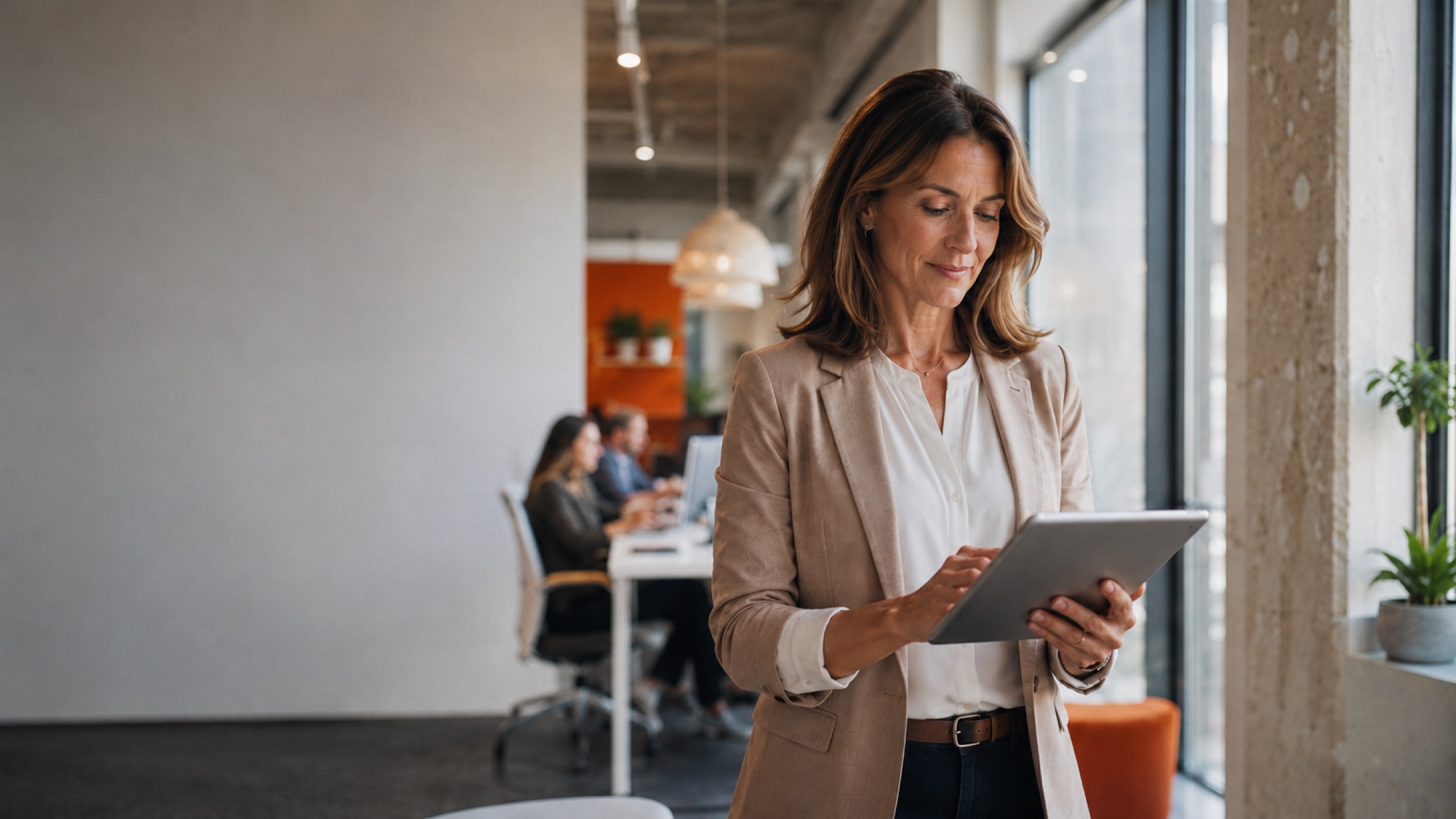 A workforce leader reviewing insights on a tablet in a modern office